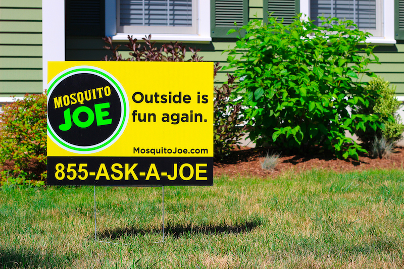 Yellow Mosquito Joe yard sign in front of a Virginia Beach home